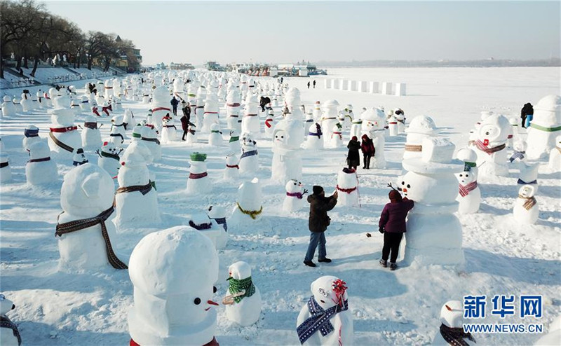 1月2日，市民、游客在雪人群中游玩觀賞（無人機拍攝）。2019個各式各樣的雪人，近日在冰城哈爾濱市的松花江畔亮相，引來眾多市民游客游玩觀賞。新華社記者 王建威 攝